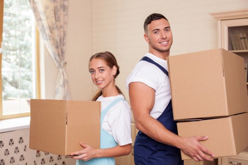 Professional movers carrying furniture down stairs in Wimbledon